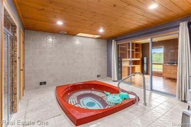 Experience refined contemporary living in this exquisite on Riverview Highlands Golf Club  in Michigan - for sale on GolfHomes.com, golf home, golf lot