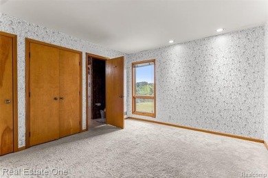 Experience refined contemporary living in this exquisite on Riverview Highlands Golf Club  in Michigan - for sale on GolfHomes.com, golf home, golf lot