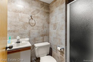 Experience refined contemporary living in this exquisite on Riverview Highlands Golf Club  in Michigan - for sale on GolfHomes.com, golf home, golf lot