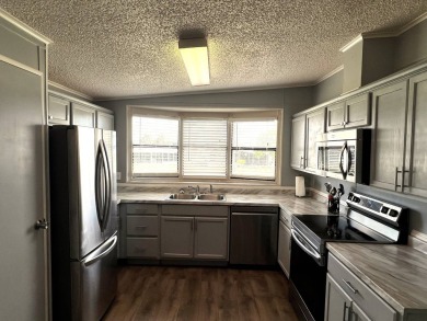 This lovely 2-bedroom, 2-bathroom gem overlooks a picturesque on Lake Henry Golf Club in Florida - for sale on GolfHomes.com, golf home, golf lot