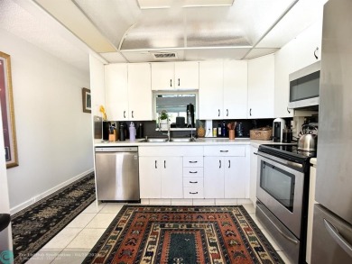 BACK ON THE MARKET WITH NEW KITCHEN WATERFALL COUNTERTOP AND on Wynmoor Golf Course in Florida - for sale on GolfHomes.com, golf home, golf lot