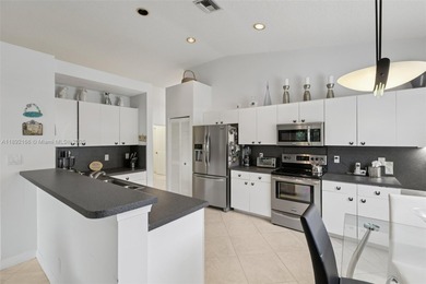 Spacious, meticulously maintained home in a gated community with on Woodmont Country Club in Florida - for sale on GolfHomes.com, golf home, golf lot