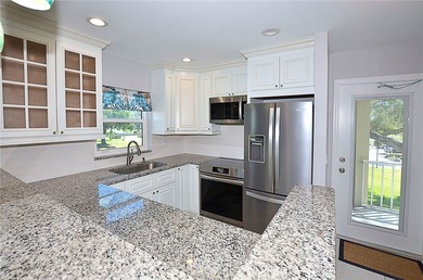 Remodeled end unit w/ serene golf/lake views, tons of natural on The American Golf Club in Florida - for sale on GolfHomes.com, golf home, golf lot