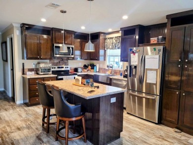 This open floor plan starts with a covered country rocking chair on Water Oak Country Club Estates in Florida - for sale on GolfHomes.com, golf home, golf lot