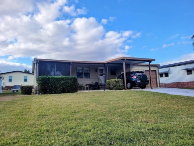 This manufactured home has a carport and a golf cart garage with on Orange Blossom Hills Golf and Country Club in Florida - for sale on GolfHomes.com, golf home, golf lot