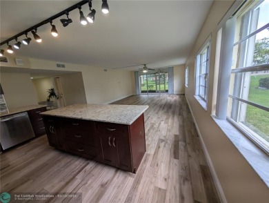 This beautifully renovated 3-bedroom, 2-bathroom corner unit at on Woodmont Country Club in Florida - for sale on GolfHomes.com, golf home, golf lot