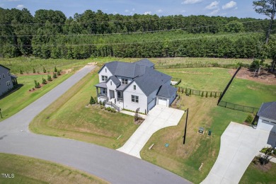 Situated atop a spacious corner lot in Hasentree, this on Hasentree Club in North Carolina - for sale on GolfHomes.com, golf home, golf lot