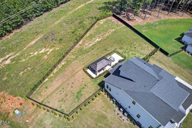 Situated atop a spacious corner lot in Hasentree, this on Hasentree Club in North Carolina - for sale on GolfHomes.com, golf home, golf lot