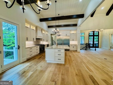 Indulge in opulent living within this custom 5-bedroom, 5.5-bath on Reynolds Lake Oconee - The Oconee in Georgia - for sale on GolfHomes.com, golf home, golf lot