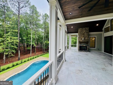 Indulge in opulent living within this custom 5-bedroom, 5.5-bath on Reynolds Lake Oconee - The Oconee in Georgia - for sale on GolfHomes.com, golf home, golf lot