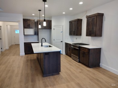 The home features a beautiful kitchen with quartz countertops on Hunters Point Golf Club in Idaho - for sale on GolfHomes.com, golf home, golf lot