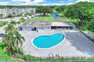 Experience serene waterfront living in this beautifully on Hillsboro Pines Golf in Florida - for sale on GolfHomes.com, golf home, golf lot