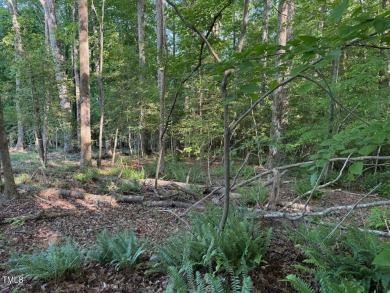 Private & wooded building lot on a quiet street of custom homes on River Golf and County Club at Lake Royale in North Carolina - for sale on GolfHomes.com, golf home, golf lot