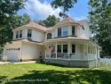This Victorian-style Colonial features a beautiful front porch for sale in Manahawkin New Jersey Ocean County County on GolfHomes.com