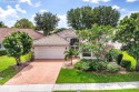 Lakefront single family home nestled amongst vibrant flowering for sale in Boynton Beach Florida Palm Beach County County on GolfHomes.com